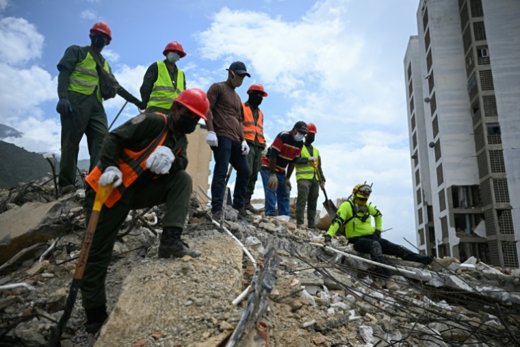 Des équipes de secours et des bénévoles recherchent des corps parmi les décombres d’un immeuble effondré à Caraballeda, au Venezuela, le 3 août 2026. ( AFP / Federico PARRA )