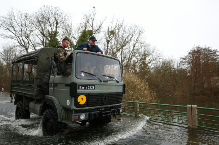 Le sous-préfet de Saintes, Guillaume Brault (D) dans un véhicule de la gendarmerie lors d'une opération de secours pour aider les personnes isolées par les crues, le 21 février 2026 à Courpignac, en Charente-maritime  ( AFP / ROMAIN PERROCHEAU )