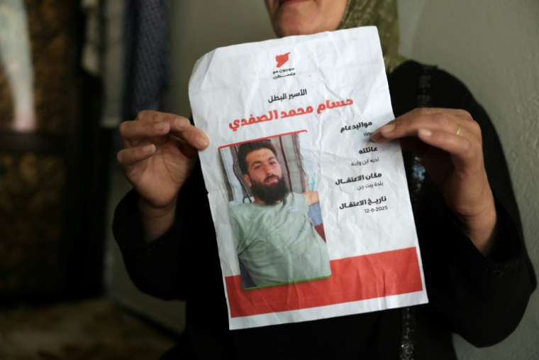 Aïcha al-Safadi tient une photo de son fils Hassan, détenu par Israël, le 29 avril 2026 à Beit Jinn ( AFP / Bakr ALkasem )