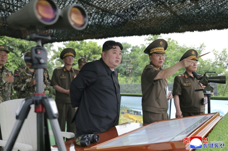 Photo diffusée par l'agence de presse officielle KCNA le 24 juillet 2025 due dirigeant nord-coéen Kim Jong Un assistant à un exercice de tirs d'artillerie dans un lieu non précisé en Corée du Nord ( KCNA VIA KNS / STR )