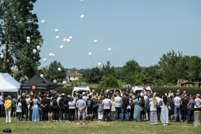 Des personnes en deuil lâchent des ballons blancs lors des obsèques de Lyhanna, une fillette de 11 ans, à Fleurance, dans le sud-ouest de la France, le 12 juin 2026 ( AFP / Ed JONES )