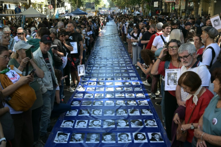 Les portraits de personnes disparues pendant la dictature militaire sur une banderole, lors des commémorations du 50e anniversaire du coup d'État militaire à Buenos Aires, le 24 mars 2026 en Argentine ( AFP / Juan Mabromata )