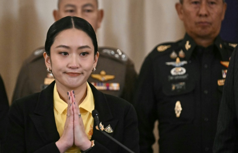 La Première ministre thaïlandaise Paetongtarn Shinawatra (g) joint ses mains lors d'une conférence de presse aux côtés du commandant des forces armées Pana Klaewplodthuk (d) au siège du gouvernement à Bangkok, le 19 juin 2025 ( AFP / Lillian SUWANRUMPHA )