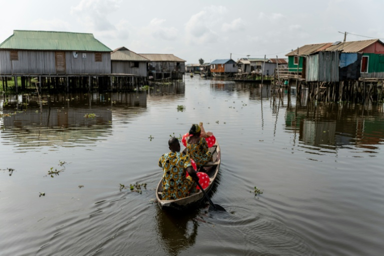 Un couple en pirogue quittent la Place des Amoureux après avoir fêté la Saint-Valentin dans la ville lacustre de Ganvié, le 10 février 2026 au Bénin ( AFP / Yanick Folly )