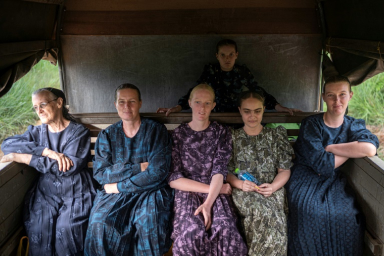 Des femmes mennonites montent dans une charrette tirée par un tracteur à Masisea, département d'Ucayali, Pérou, le 20 mars 2025 ( AFP / ERNESTO BENAVIDES )