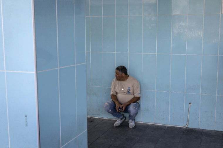Un homme patiente près d'un abri après que les sirènes prévenant d'une attaque de missile a retenti à Nahariya, dans le nord d'Israël, le 27 mars 2026 ( AFP / JOHN WESSELS )