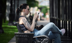 Une femme assise sur un banc utilise son smartphone à Moscou, le 30 juillet 2025 ( AFP / Alexander NEMENOV )