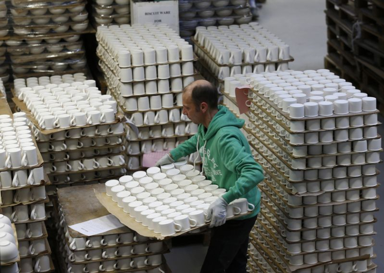 Un ouvrier transporte des tasses dans l'entrepôt de l'usine Portmeirion à Stoke-on-Trent