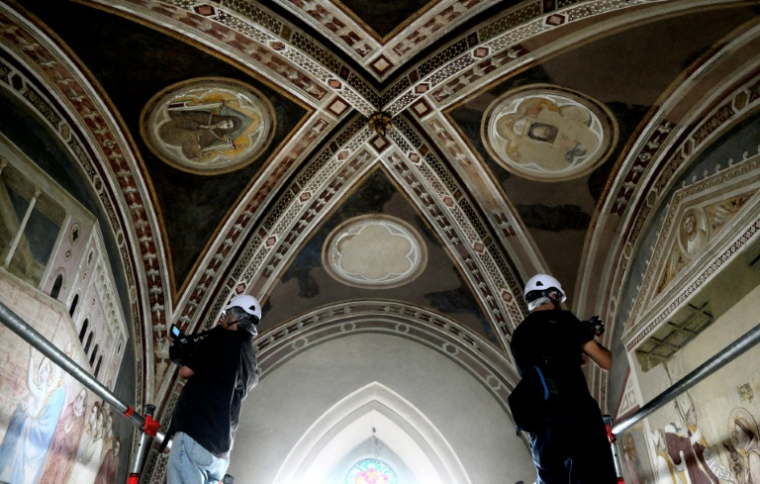 Des cameramen filment les fresques lors d'une visite de presse marquant la fin des travaux de restauration des fresques du XIVe siècle de Giotto dans la basilique Santa Croce à Florence, le 12 juin 2026 ( AFP / Tiziana FABI )