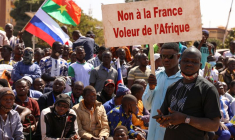 Une personne à Ouagadougou tient une pancarte alors que les gens protestent contre la présence de la France au Burkina Faso