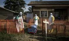 Des personnels médicaux désinfectent le cercueil d'un patient décédé à l'intérieur d'un centre de traitement d'Ebola géré par l'Alliance pour l'action médicale internationale (Alima), le 13 août 2018 à Beni, en RDC ( AFP / John WESSELS )