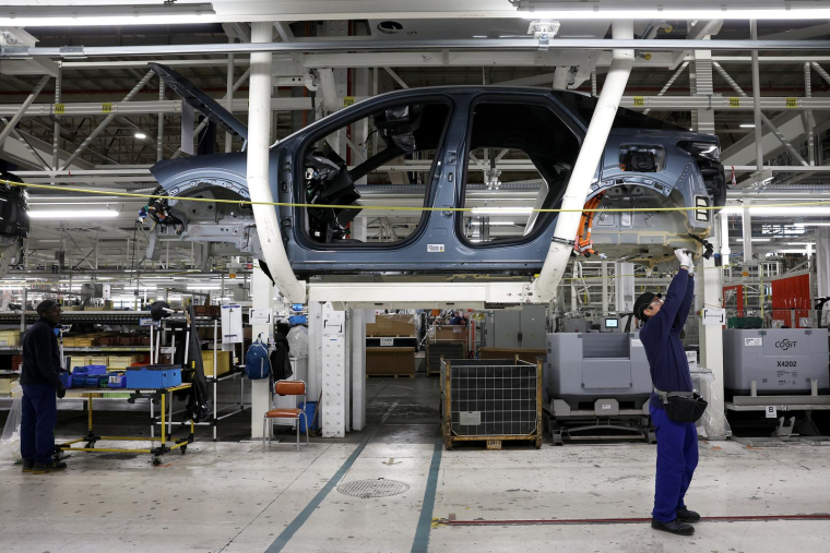 Des employés travaillent sur la chaîne de production de la nouvelle voiture électrique Peugeot e-3008 et e-5008 à l'usine Stellantis de Sochaux, le 3 octobre 2024. ( AFP / FREDERICK FLORIN )