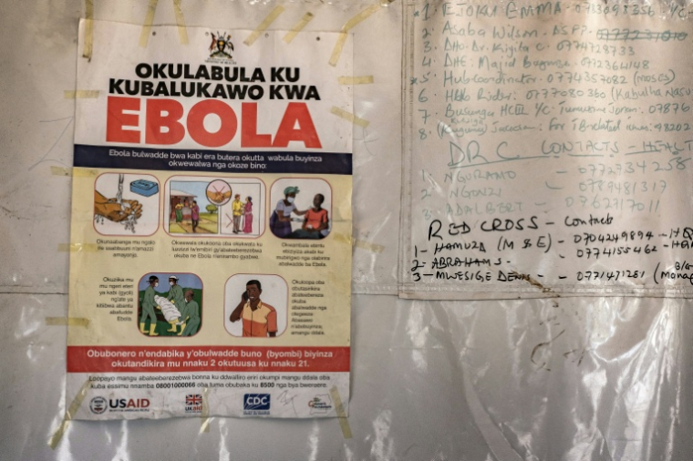 Une affiche d'information indique les numéros d'urgence liés à Ebola,dans une tente au poste-frontière de Busunga, entre l'Ouganda et la République démocratique du Congo, à Bundibugyo, le 18 mai 2026.  ( AFP / Badru Katumba )