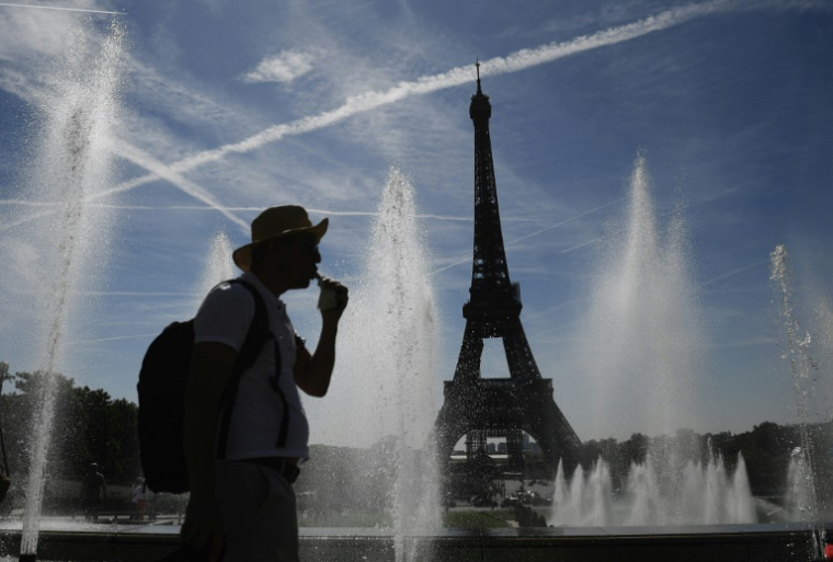 Un homme se rafraîchit près de fontaines à Paris le 16 juin 2022 ( AFP / JULIEN DE ROSA )
