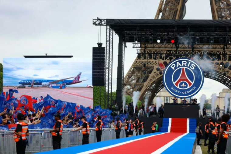 Vue du Champs-de-Mars où les joueurs du PSG vont être fêtés après leur deuxième titre en Ligue des champions, tandis que leur avion apparaît sur l'écran géant à son arrivée à Charles-de-Gaulle, le 30 mai 2026 à Paris ( AFP / Kenzo TRIBOUILLARD )