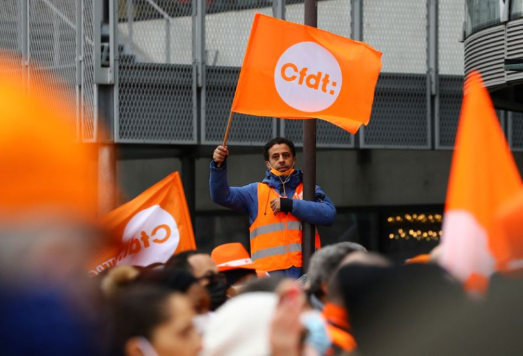 Des travailleurs tenant des drapeaux de la CFDT