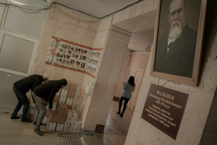 Des employés de l'hôpital psychiatrique de Poltava, en Ukraine, déchargent du matériel fourni par l'ONG AICM le 19 mars 2025 ( AFP / Ivan SAMOILOV )