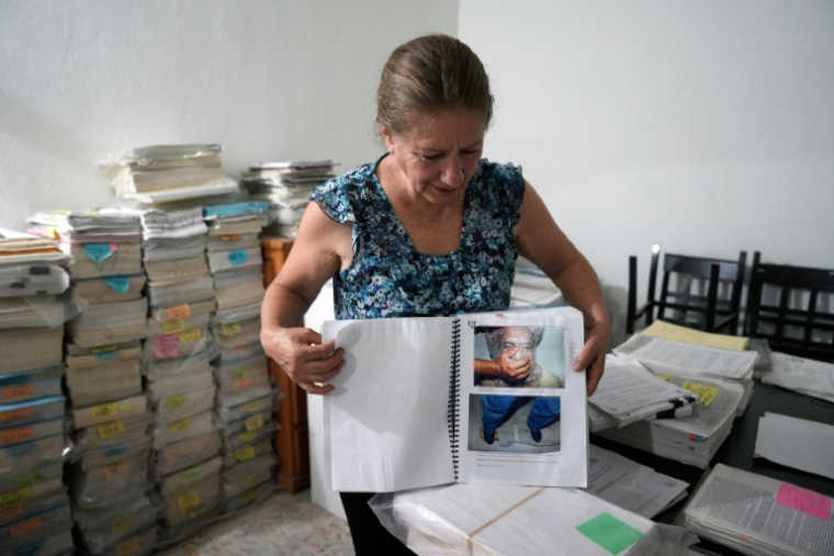 Guadalupe Vallarta, la soeur d'Israel Vallarta en détention depuis près de 20 au Mexique, ouvre un des dossiers de la procédure qu'elle conserve chez elle à Mexico le 25 mai 2025 ( AFP / Zina DESMAZES )