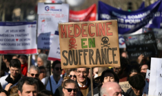 Un manifestant brandit une pancarte "Médecine en souffrance" lors d'une mobilisation du secteur privé, le 14 février 2023 à Paris ( AFP / Emmanuel DUNAND )