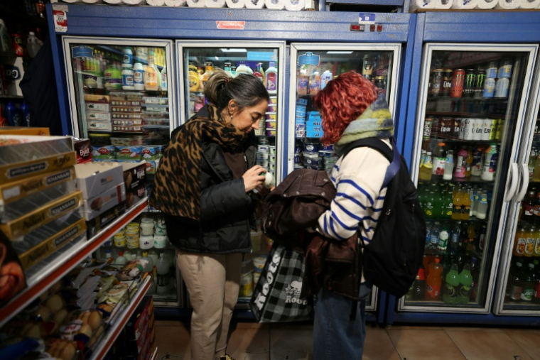 Une femme vérifie le prix du lait dans une boutique de Téhéran, en Iran, le 7 janvier 2026 ( AFP / ATTA KENARE )