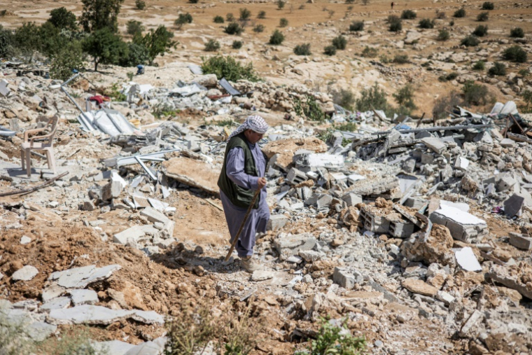 Un Palestinien marche au milieu des décombres du hameau de Khallet Al-Dabaa, en Cisjordanie occupée, le 6 mai 2025, après la destruction par les forces israéliennes des habitations de ce village ( AFP / JOHN WESSELS )