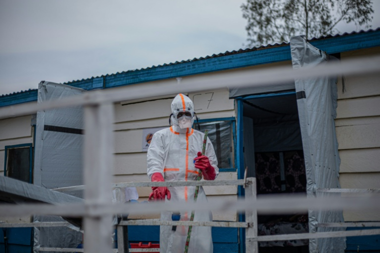 Un agent sanitaire en combinaison de protection commence les opérations de nettoyage et de désinfection au centre de traitement Ebola (CTE) de Rwampara, le 13 juillet 2026 à Bunia, dans la province de l'Ituri, en RDC ( AFP / BENEDICTION MURHABAZI )