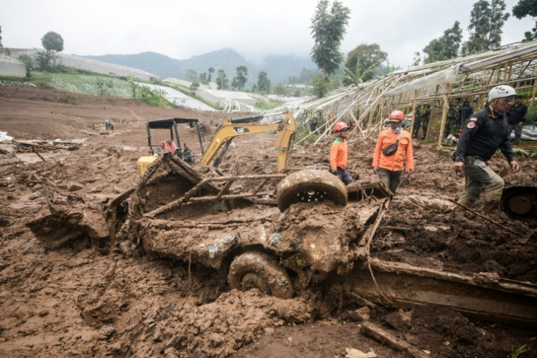 Des secouristes recherchent des victimes ensevelies par un glissement de terrain dans le village de Pasirlangu, à Bandung, dans l'ouest de l'île indonésienne de Java, le 26 janvier 2026 ( AFP / Timur Matahari )