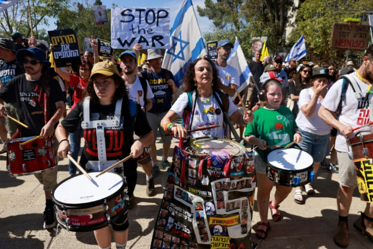 Des familles d'otages retenus dans la bande de Gaza et personnes les soutenant brandissent des panneaux et drapeaux israéliens lors d'une manifestation appelant à les libérer, à Jérusalem, le 17 août 2025 ( AFP / Menahem Kahana )