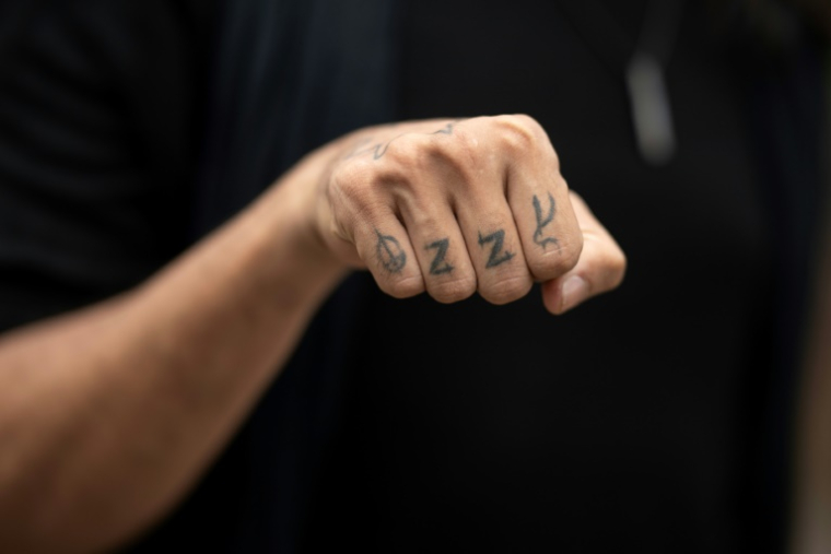 Un fan avec un tatouage d'Ozzy Osbourne sur les phalanges arrive au concert "Back to The Beginning" de Black Sabbath à Birmingham, dans le centre de l'Angleterre, le 5 juillet 2025 ( AFP / Oli SCARFF )