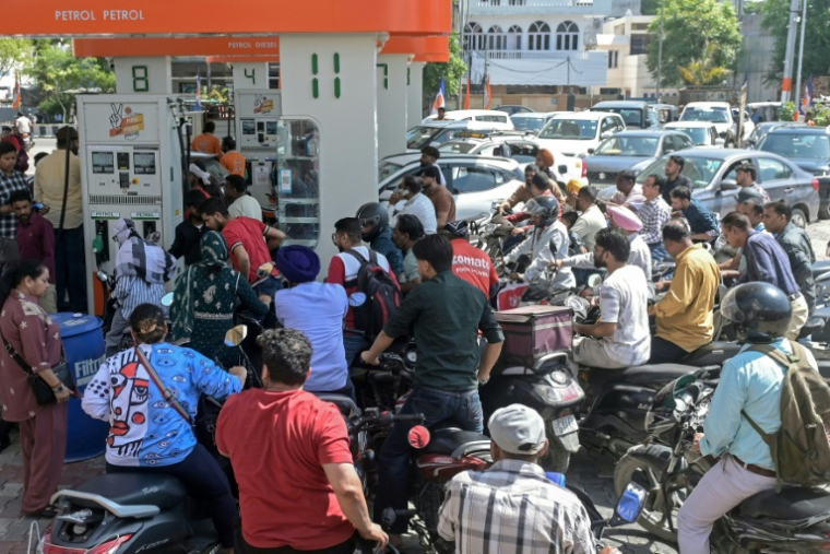Des personnes se précipitent pour faire le plein de leur véhicule dans une station-service à Amritsar, le 27 mars 2026, en Inde ( AFP / Narinder NANU )