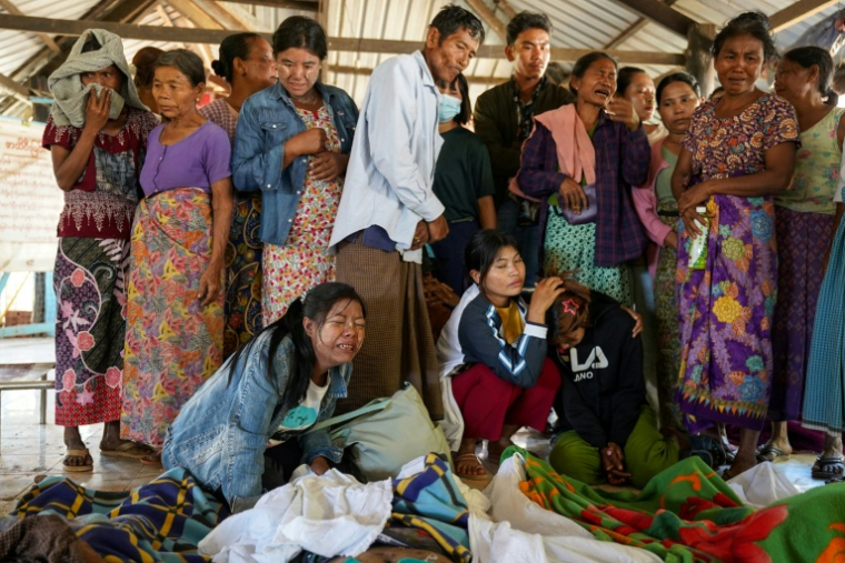 Les proches des victimes pleurent leurs défunts, dont les corps sont exposés dans un cimetière avant leur inhumation, après une frappe aérienne de l'armée birmane contre un hôpital à Mrauk U, dans l'ouest de l'Etat de Rakhine, le 11 décembre 2025. Plus de 30 personnes ont été tuées dans l'attaque. ( AFP / STR )