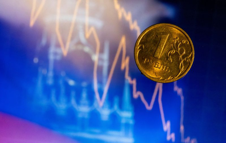 Pièce d'un rouble russe devant un écran affichant la tour Spasskaya du Kremlin à Moscou