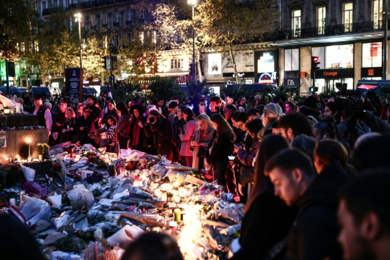 Des personnes se recueillent devant le mémorial dédié aux victimes de l'attaque du 13-Novembre, place de la République, à Paris, le 13 novembre 2025 ( AFP / Thibaud MORITZ )