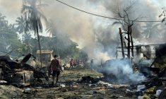 Des habitants au milieu de débris encore fumants après une frappe aérienne militaire ayant visé un marché et un pont adjacent à Kyauktaw, dans l'État de Rakhine, le 28 septembre 2026 en Birmanie ( AFP / - )