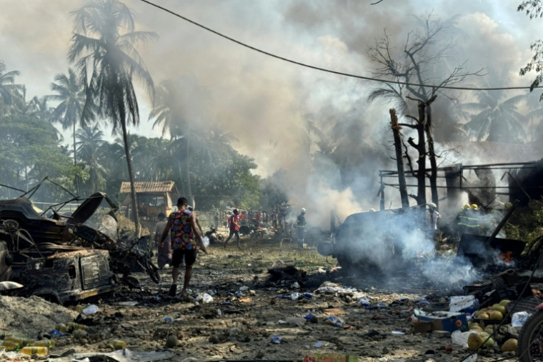 Des habitants au milieu de débris encore fumants après une frappe aérienne militaire ayant visé un marché et un pont adjacent à Kyauktaw, dans l'État de Rakhine, le 28 septembre 2026 en Birmanie ( AFP / - )