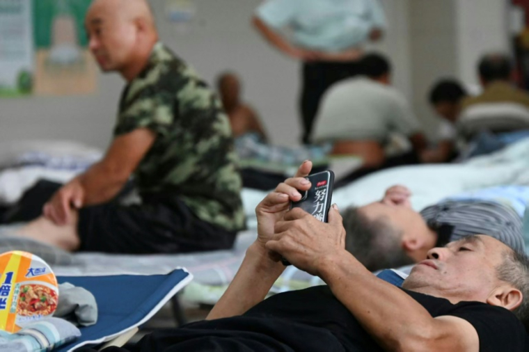 Des habitants évacués à l'approche du typhon Bavi se reposent dans un centre à Yueqing, dans la province du Zhejiang (est) en Chine, le 11 juillet 2026 ( CN-STR / - )