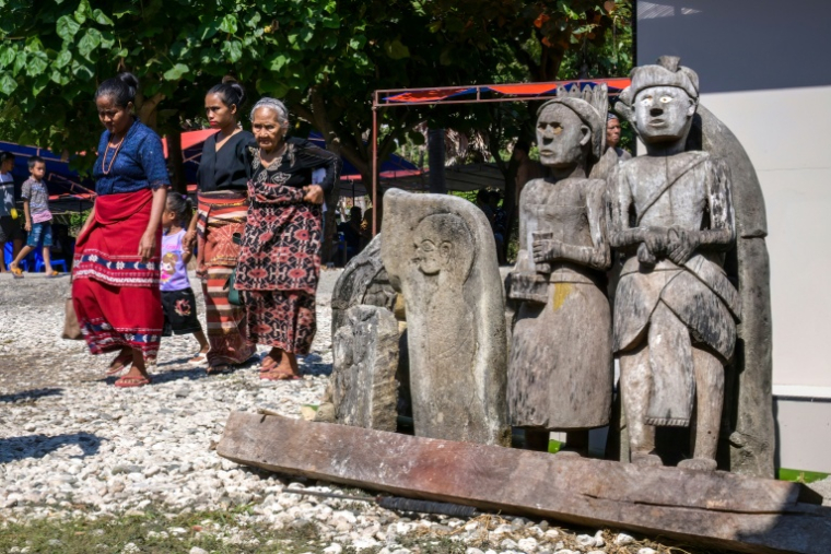 Des personnes en deuil passent devant la tombe de Dicki Takandjandji, membre de la classe noble "maramba" lors d'une cérémonie funéraire de marapu au village de Kaburu, à Waingapu, sur l'île de Sumba, le 26 juin 2026 en Indonésie ( AFP / BAY ISMOYO )