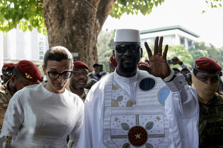 Le président guinéen et candidat à la présidence Mamadi Doumbouya (CR) et son épouse Lauriane Doumbouya (CL) arrivent pour voter dans un bureau de vote à Conakry le 28 décembre 2025, lors de l'élection présidentielle guinéenne.  ( AFP / Patrick MEINHARDT )