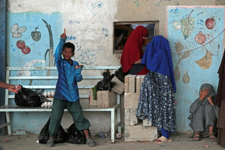 Des enfants se tiennent devant un magasin dans le camp de Roj, construit pour accueillir des proches de jihadistes présumés, dans le nord-est de la Syrie, le 5 octobre 2026 ( AFP / Delil SOULEIMAN )