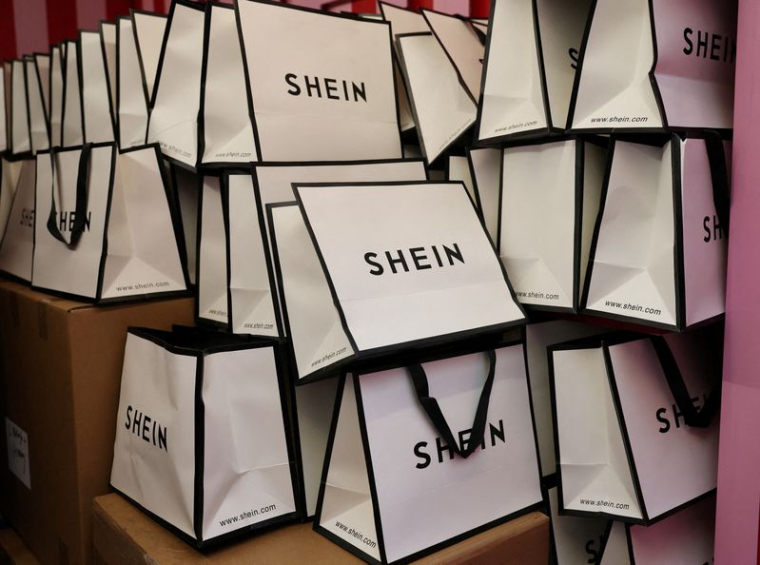 FILE PHOTO: A company logo for fashion brand Shein is seen on a pile of gift bags on its Christmas bus as part of a nationwide promotional tour in Liverpool, Britain