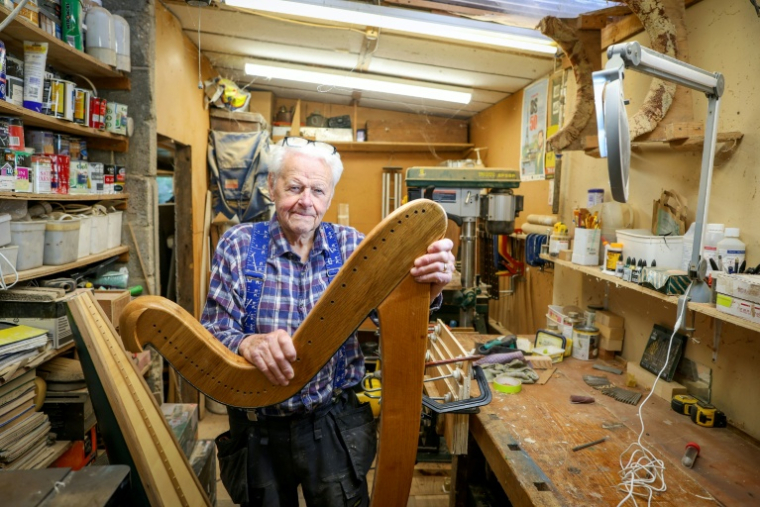 Noel Anderson, 89 ans, pose dans son atelier de fabrication de harpes, le 29 septembre 2025 à Strabane, en Irlande du Nord ( AFP / Paul Faith )