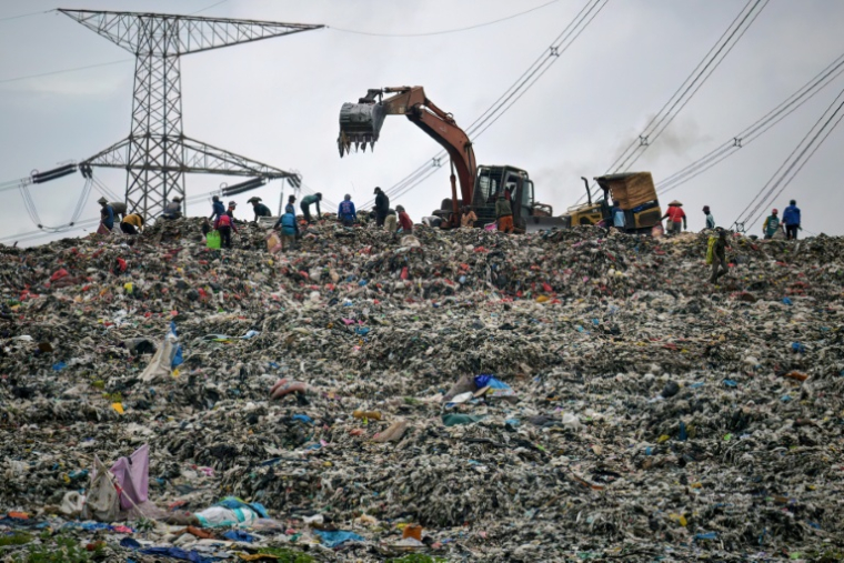 Des engins de chantier nivellent un énorme tas de déchets à la décharge de Cipayung à Depok, le 15 janvier 2026 en Indonésie ( AFP / BAY ISMOYO )