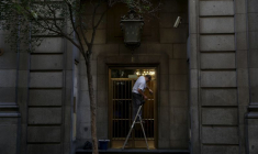 Un homme travaille en nettoyant la porte d'entrée d'un bâtiment