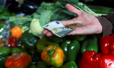 Des clients font leurs courses sur un marché local à Paris