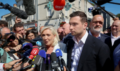 Marine Le Pen (c), cheffe du groupe parlementaire Rassemblement national (RN) et candidate à la présidentielle de 2027, et Jordan Bardella, président du RN, entourés de journalistes à leur arrivée à La Flèche pour un rassemblement de campagne, le 8 juillet 2026 dans la Sarthe ( AFP / FRED TANNEAU )