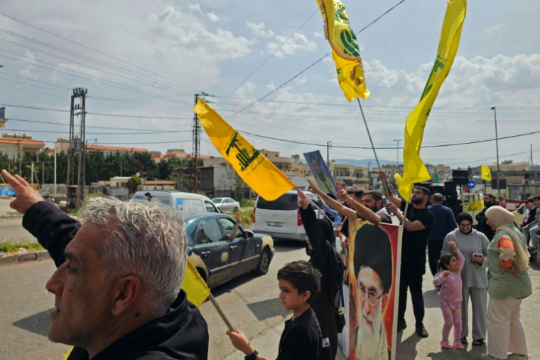 Des habitants brandissent des drapeaux du Hezbollah tandis que des personnes déplacées rentrent chez elles en voiture dans la région d'Habbouch, dans le sud du Liban, le 17 avril 2026 ( AFP / - )