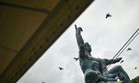 Des colombes volent au-dessus de la statue de la paix, à Nagasaki le 9 août 2025, jour du 80e anniversaire du bombardement atomique de la ville ( AFP / Philip FONG )