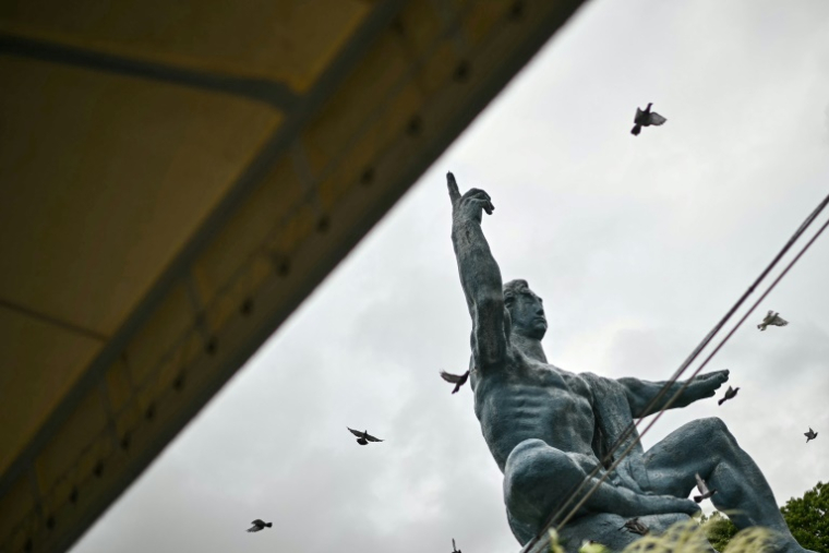 Des colombes volent au-dessus de la statue de la paix, à Nagasaki le 9 août 2025, jour du 80e anniversaire du bombardement atomique de la ville ( AFP / Philip FONG )