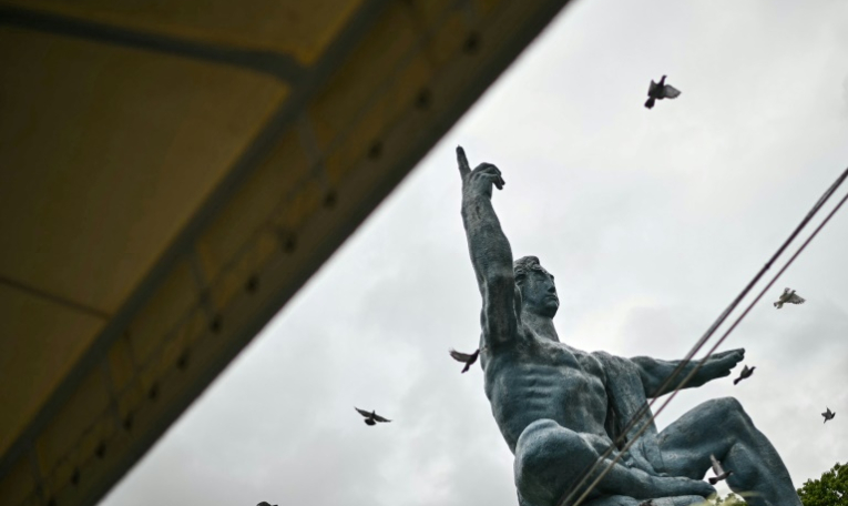 Des colombes volent au-dessus de la statue de la paix, à Nagasaki le 9 août 2025, jour du 80e anniversaire du bombardement atomique de la ville ( AFP / Philip FONG )