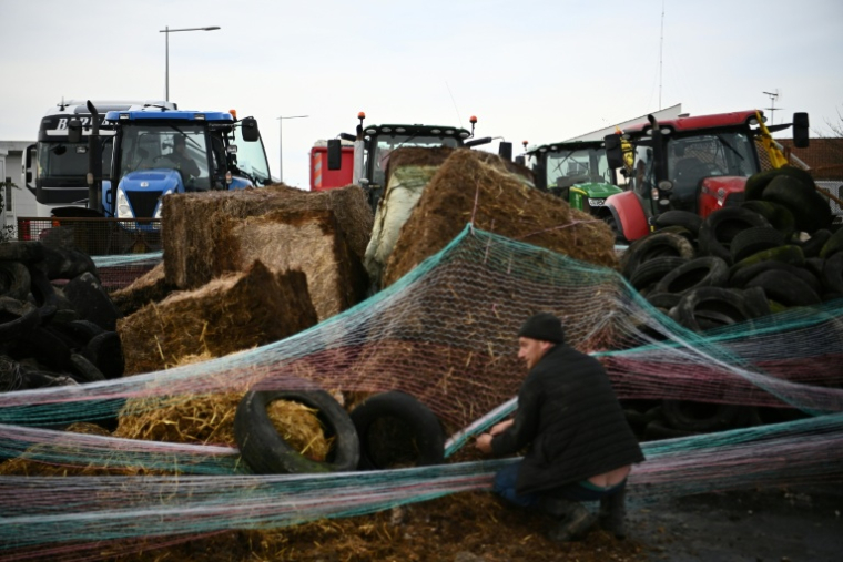 Des agriculteurs manifestant contre l'accord UE-Mercosur, érigent une barricade lors du blocage d'un dépôt pétrolier sur le port de La Pallice à La Rochelle, le 12 janvier 2026 en Charente-Maritime ( AFP / Christophe ARCHAMBAULT )